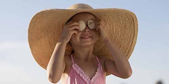 Girl in hat and swimsuit in sun