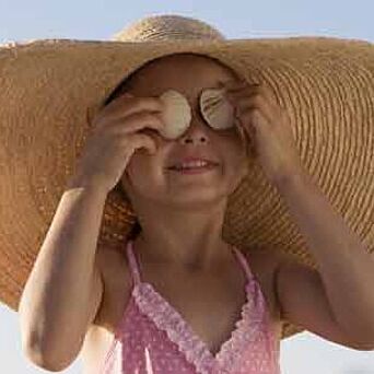 Girl in hat and swimsuit in sun