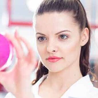 Microbiologist holding pink petri dish