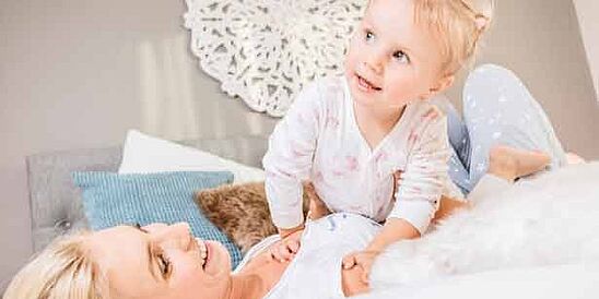 mom and child on bed with blue pillow