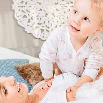 mom and child on bed with blue pillow