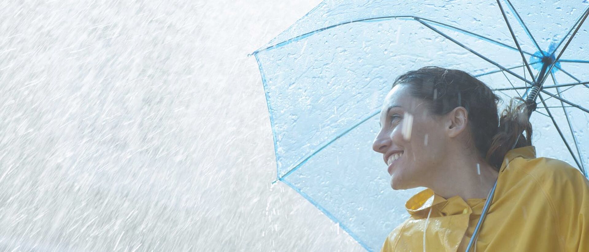 Woman with PFAS tested raincoat and umbrella in the rain