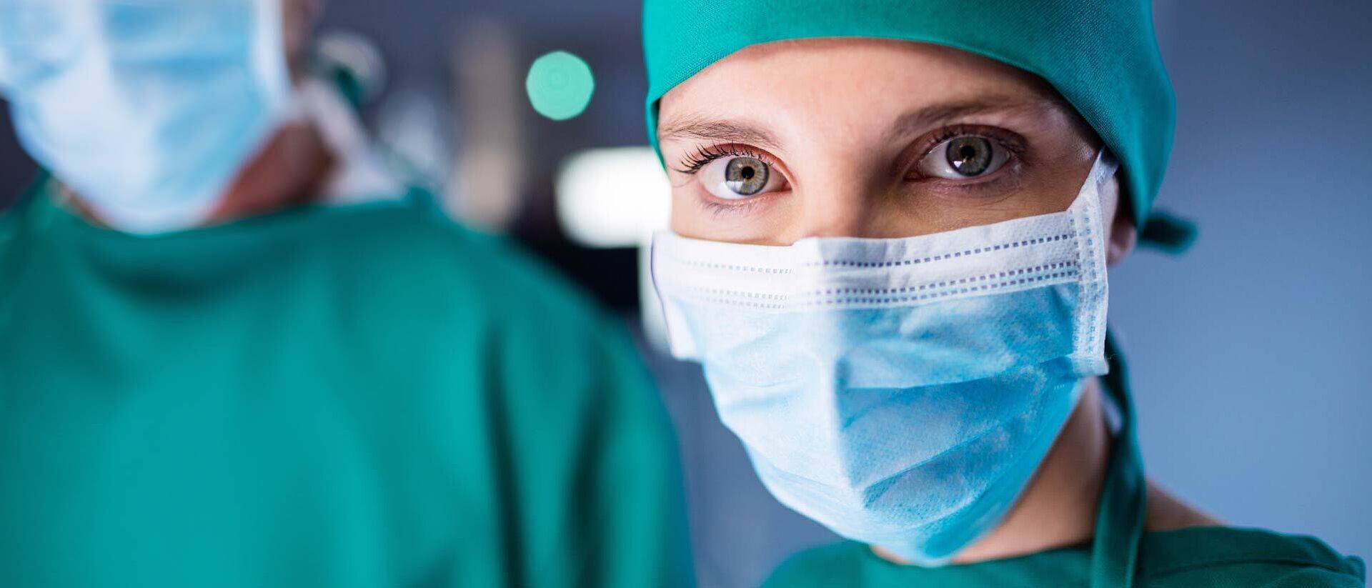 Doctors wearing surgical gowns, face masks and head coverings