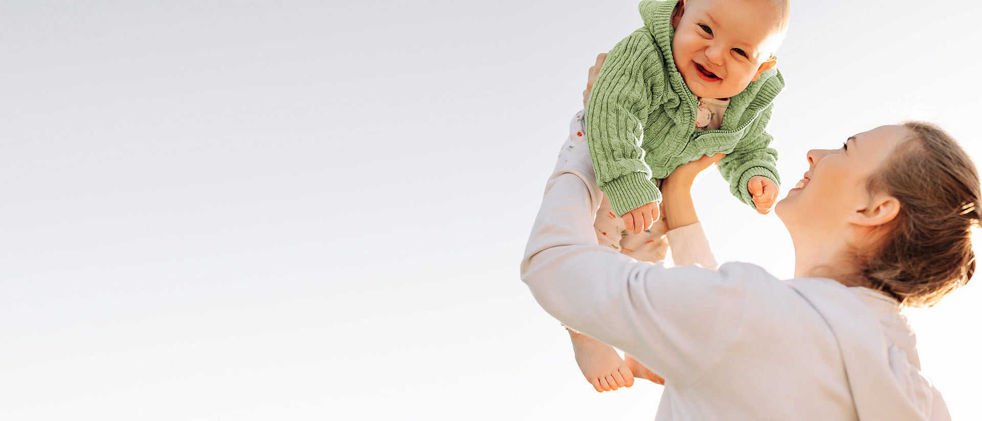 mom holding baby wearing sustainable clothing