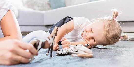 Child playing on carpeted floor with toys