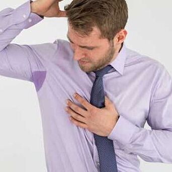 Man looking at sweat on his shirt