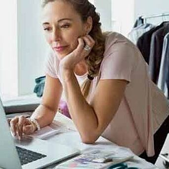 Female working on laptop in apparel design studio