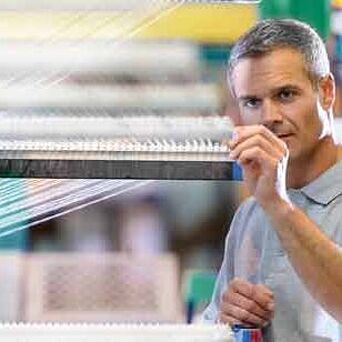 Male worker adjusting a textile machine