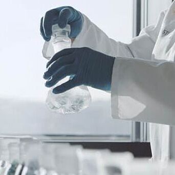 Lab technician holding beakers