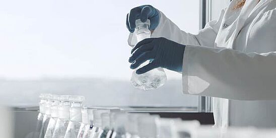 Lab technician holding beakers