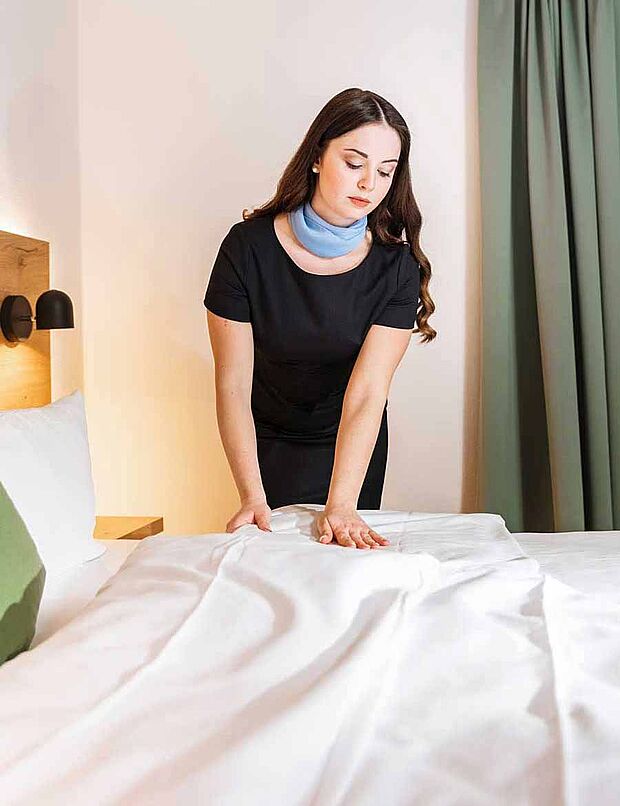 Hotel staff making a bed