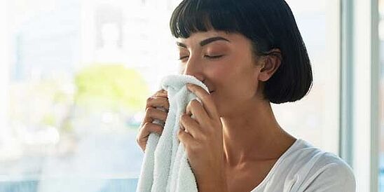 Woman smelling a fresh, white towel