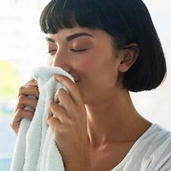 Woman smelling a fresh, white towel