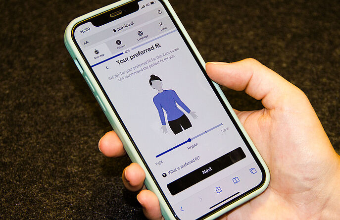 Hand holding a phone with Presize fitting software