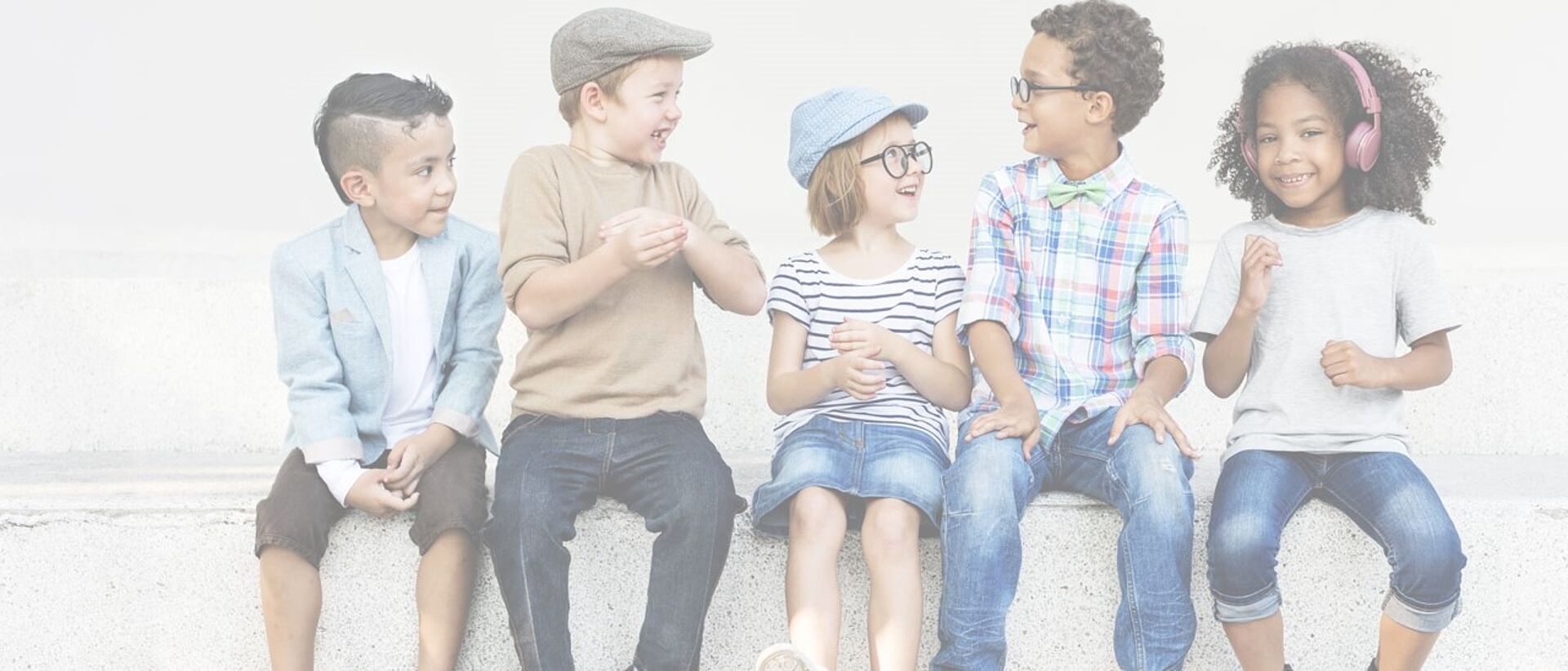 5 kids chatting on a bench outside