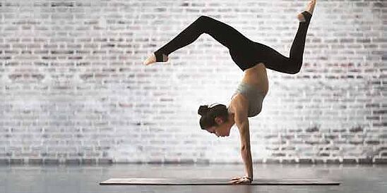 Yogi posed in handstand on yoga mat