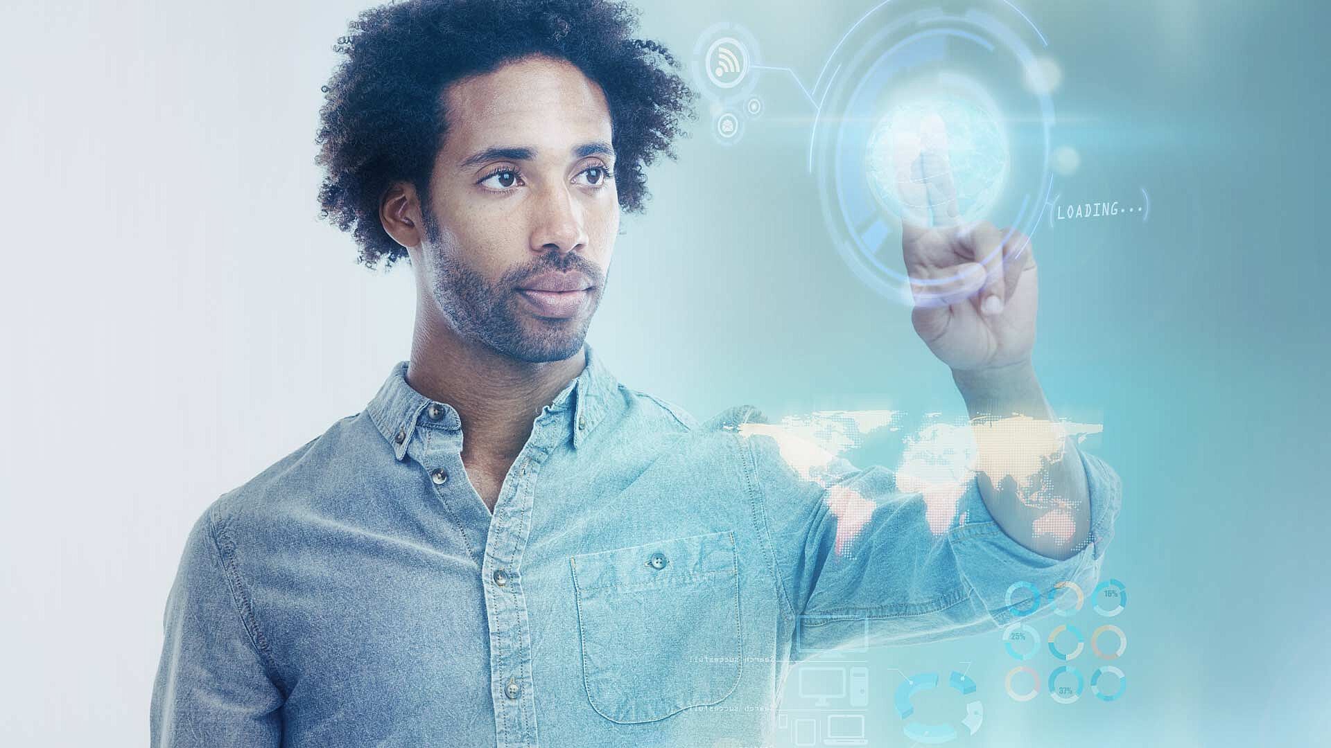 Man wearing denim shirt touching digital screen