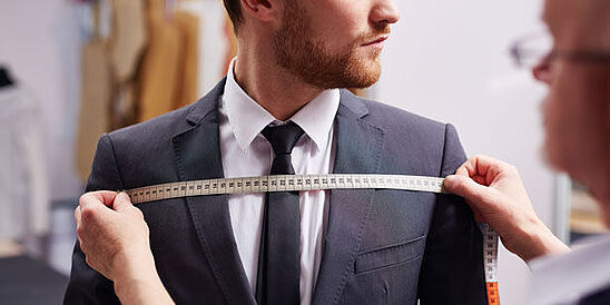 Clothing engineer measuring fit of a man's suit