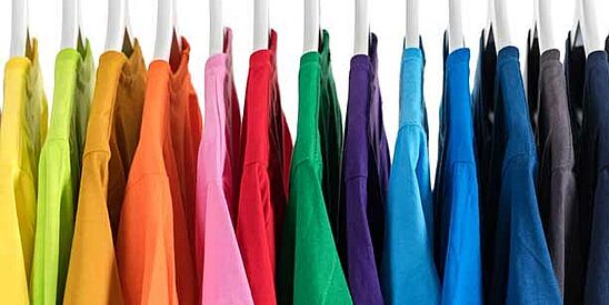 shirts in many colors hanging on a rack