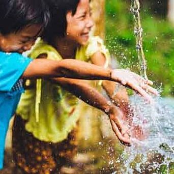 Two children splashing in clean water