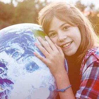 Young girl holding a globe.