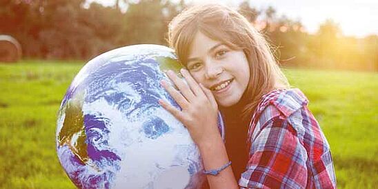 Young girl holding a globe.