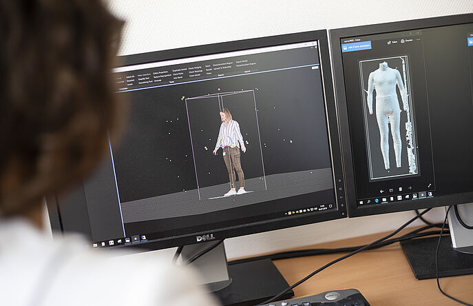 Clothing engineer in front of computer screens with accurate avatars