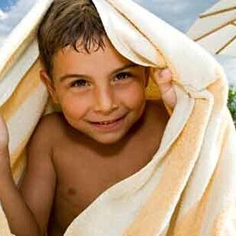 Boy shielding sun with towel