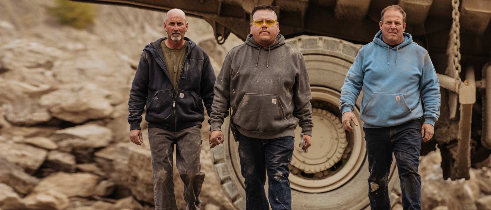 Three men in Carhartt workwear walking on job site