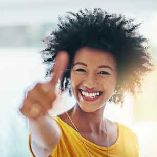 Woman wearing yellow shirt and giving thumbs up