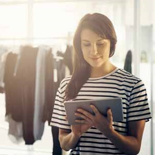 Apparel designer in striped shirt using a tablet