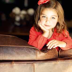 Girl in red shirt on leather couch