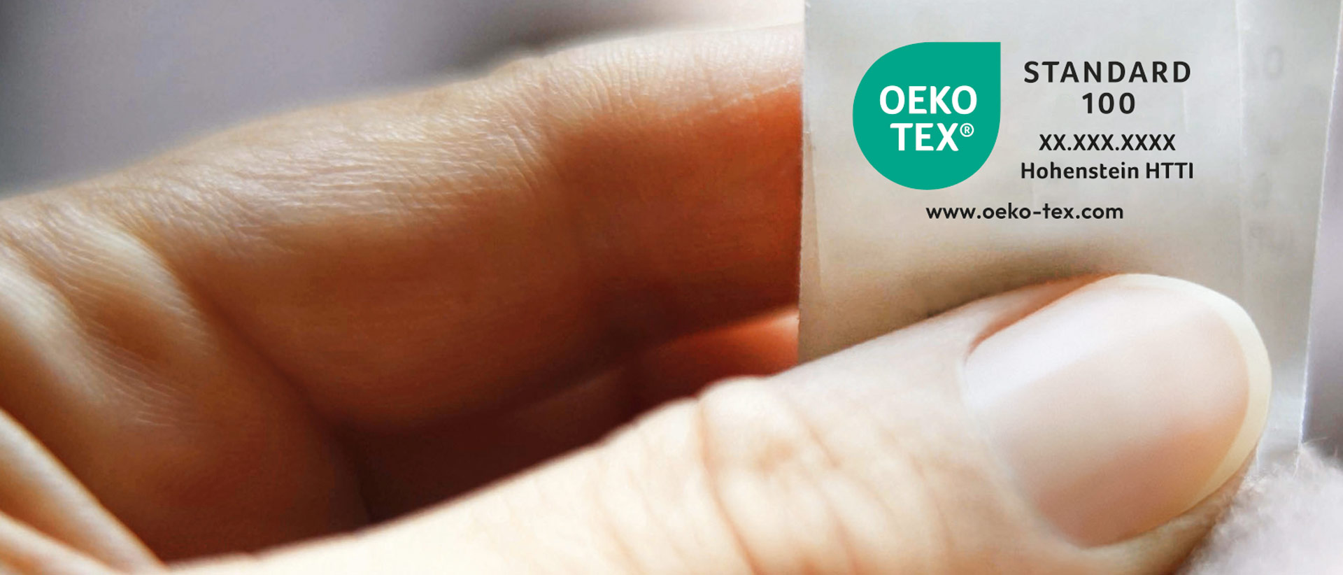 Hand holding a textile with OEKO-TEX® STANDARD 100 sew-in label