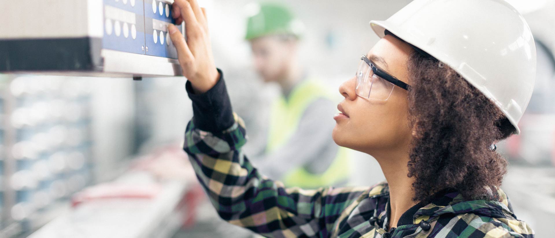 Textile worker in protective gear, checking machine