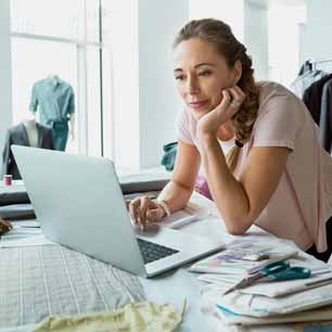 Female working on laptop in apparel design studio