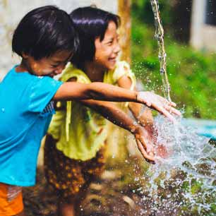 Two children splashing in clean water