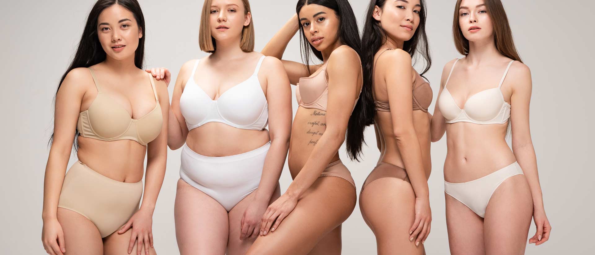 5 women wearing neutral colored period panties and bras