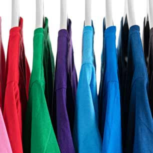 shirts in pink, red, green, purple and blues on a hanging rack