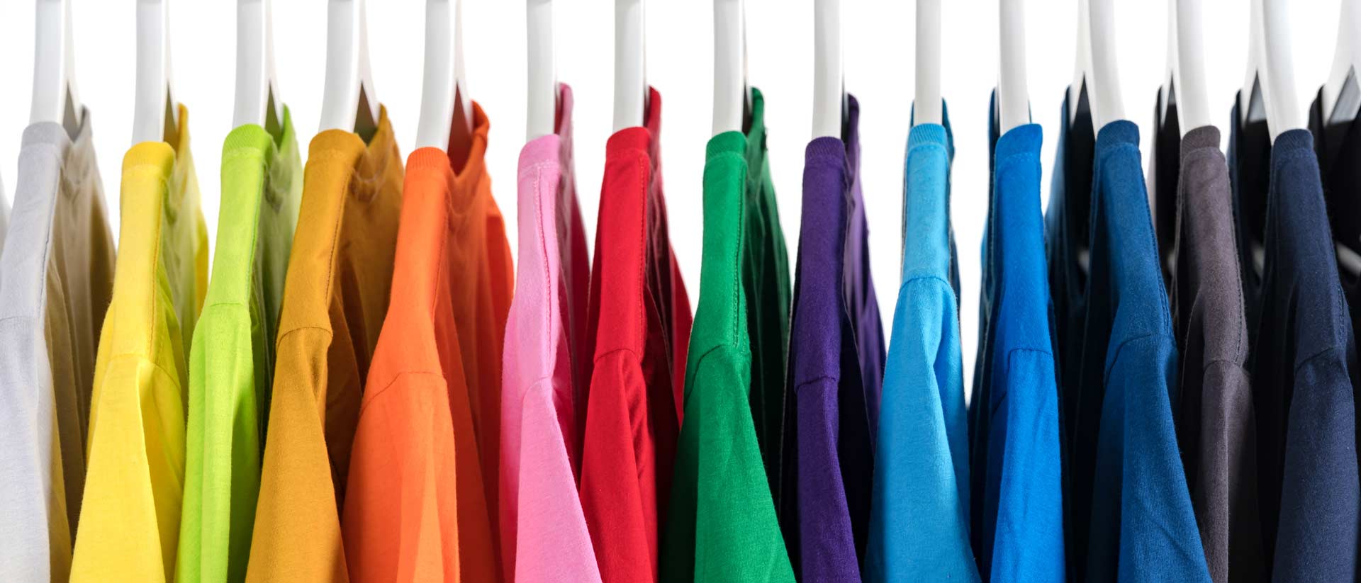 shirts in several colors hanging on a rack