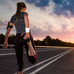 Runner stretching on road