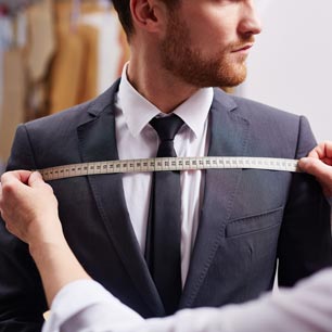 Apparel engineer measuring man's chest