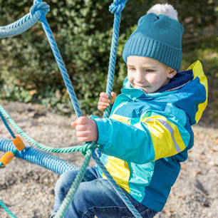 Child on playground wearing coat and hat