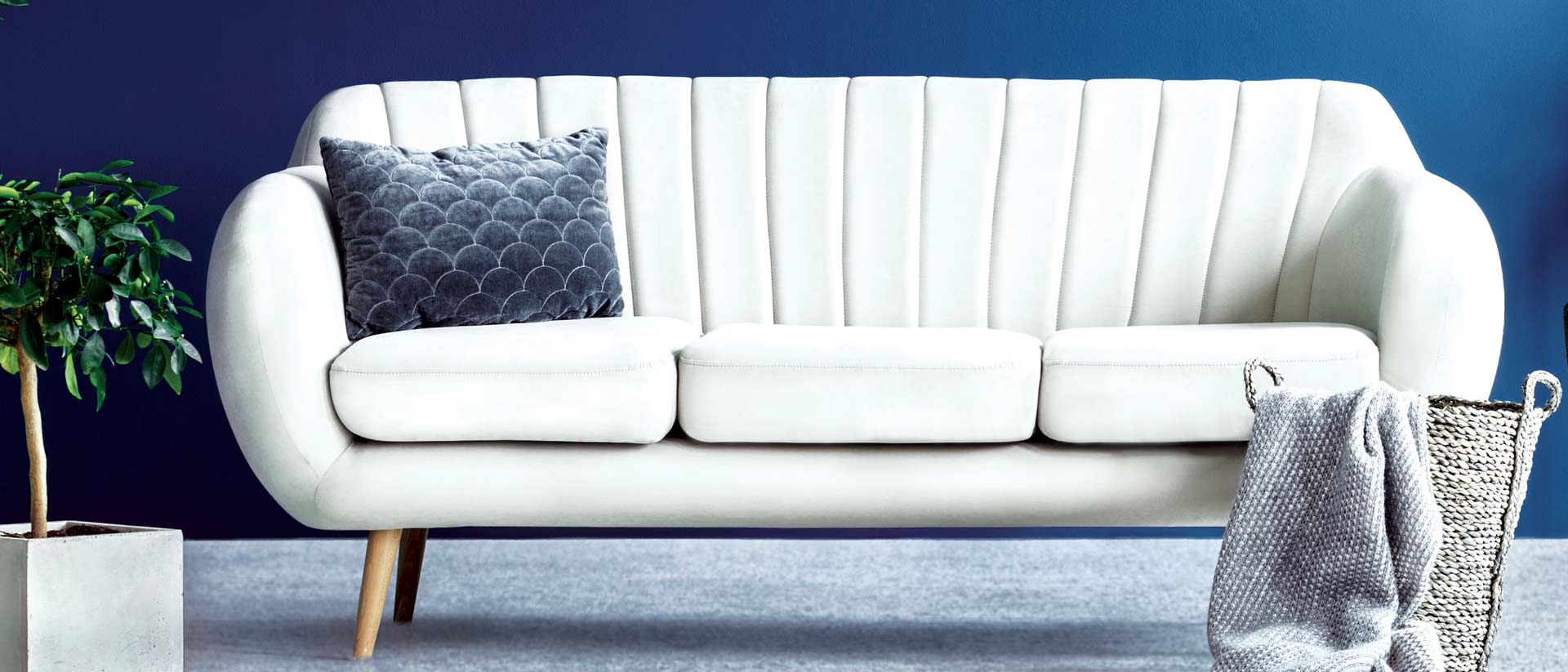 White couch against a deep blue wall. 