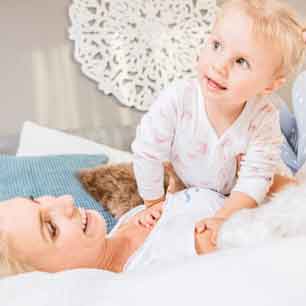 mom and child laying on bed