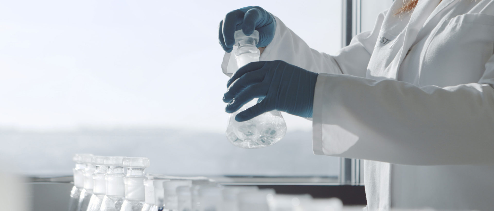 technician holding beakers in accredited laboratory