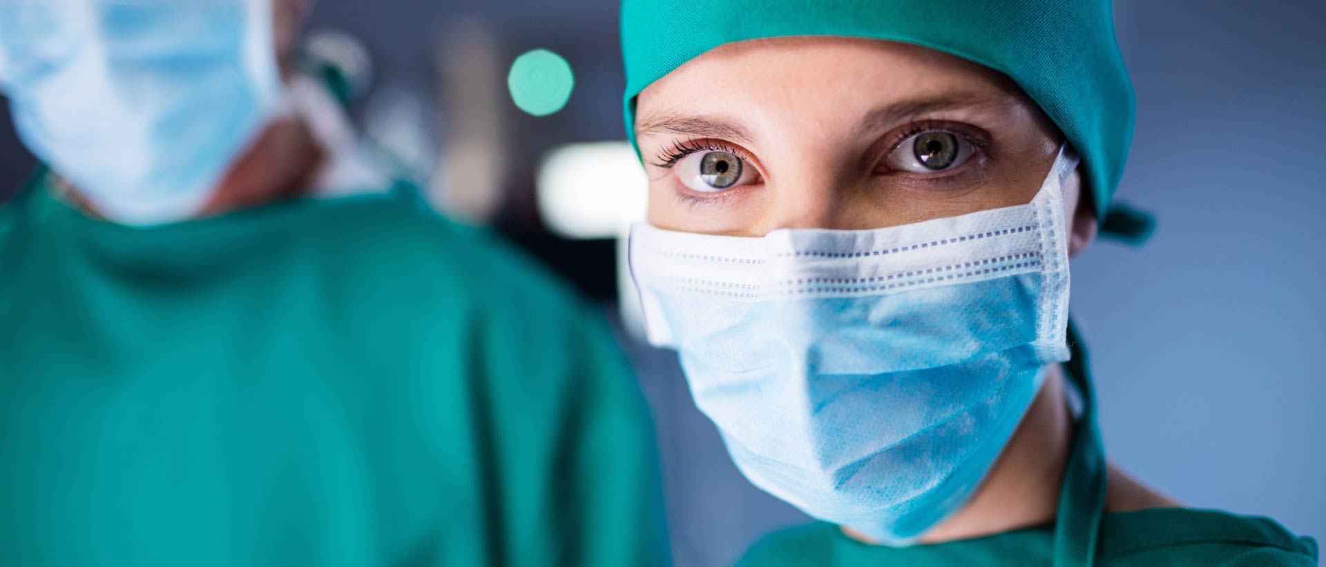 Doctors wearing surgical gowns, face masks and head coverings