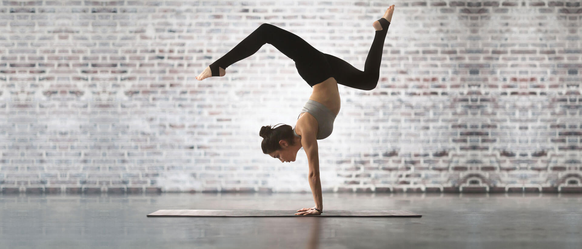 Yogi posed in handstand on yoga mat