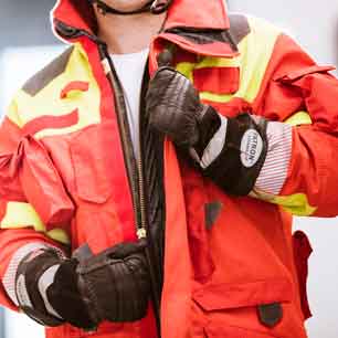 Firefighter wearing protective gloves and unzipping jacket