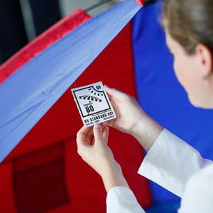 Textile engineer examining UV STANDARD 801 tag on a tent